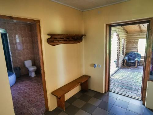 a bathroom with a bench in a room with a toilet at Minavuonė in Telšiai