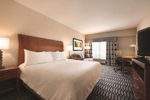ein Hotelzimmer mit einem Bett und einem TV in der Unterkunft Hilton Garden Inn Akron-Canton Airport in North Canton