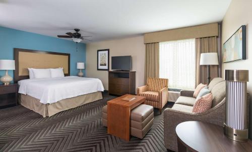 a hotel room with a bed and a living room at Homewood Suites by Hilton Akron/Fairlawn in Akron