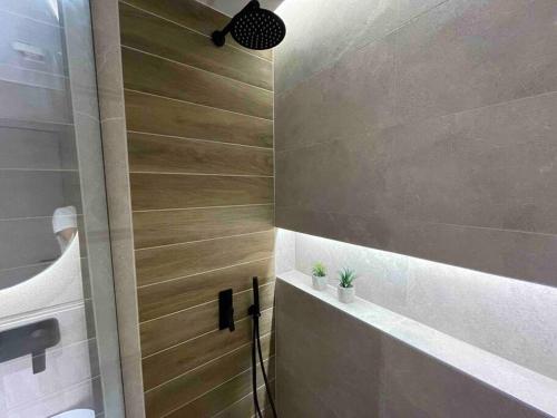 a shower with a wooden door in a bathroom at Ladadika Luxury Apartment #4 in Thessaloniki