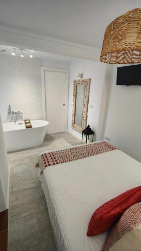 a bedroom with a bed and a tub and a sink at La Damajuana, Casa Rural in Montejaque