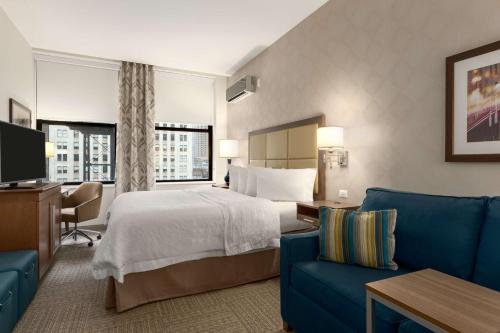 um quarto de hotel com uma cama e um sofá azul em Hampton Inn Chicago Downtown/N Loop/Michigan Ave em Chicago