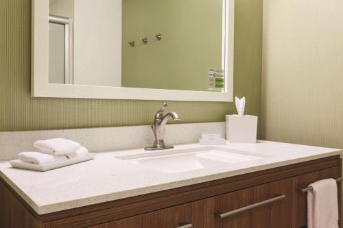 bagno con lavandino e specchio di Home2 Suites by Hilton College Station a College Station