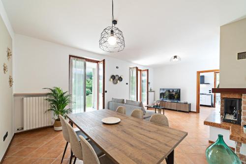 - un salon avec une table et des chaises en bois dans l'établissement VILLA IDA - Regarda Travel, à Costermano