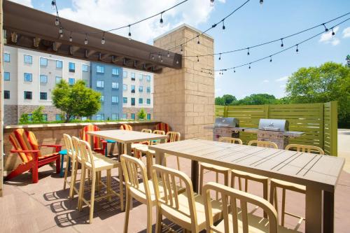 a patio with tables and chairs and a grill at Home2 Suites Charlotte I-77 South in Charlotte