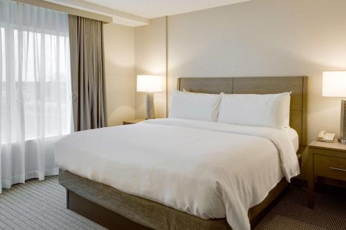 a hotel room with a large bed and a window at Embassy Suites by Hilton Columbus Dublin in Dublin