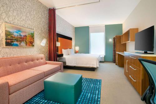 um quarto de hotel com um sofá e uma cama em Home2 Suites Charlotte I-77 South em Charlotte
