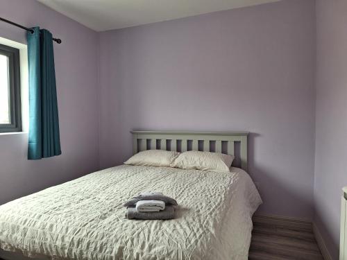 a bedroom with a bed with a towel on it at Teach Aindí (newly renovated cottage) in Belmullet