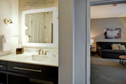 a bathroom with a sink and a mirror and a couch at Homewood Suites by Hilton Dallas Arlington South in Arlington