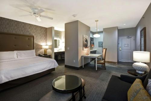 a hotel room with a bed and a living room at Homewood Suites by Hilton Dallas Arlington South in Arlington