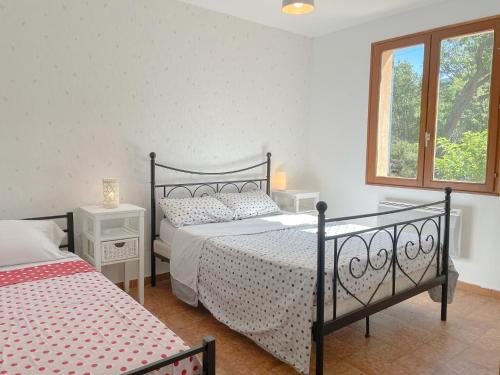 a bedroom with two beds and a window at Valansolette in Beynes