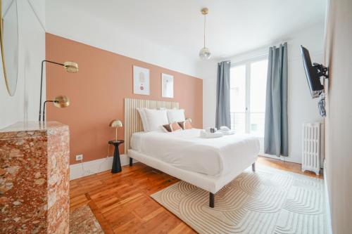 ein Schlafzimmer mit einem weißen Bett und einem großen Fenster in der Unterkunft Apartment next to Louis Vuitton Fondation in Neuilly-sur-Seine