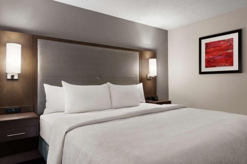 a large white bed in a hotel room at Addison Suites in Addison