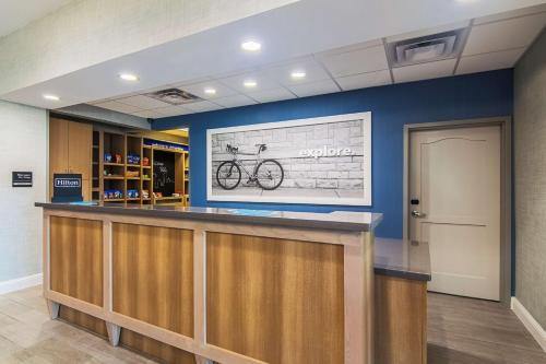 a bar in a hospital lobby with a bike on the wall at Hampton Inn & Suites-Dallas/Richardson in Richardson