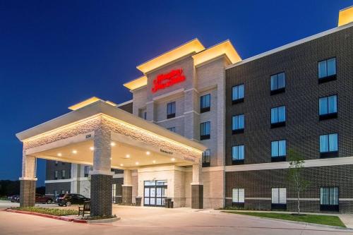 a hotel with a red sign on the front of it at Hampton Inn & Suites-Dallas/Richardson in Richardson