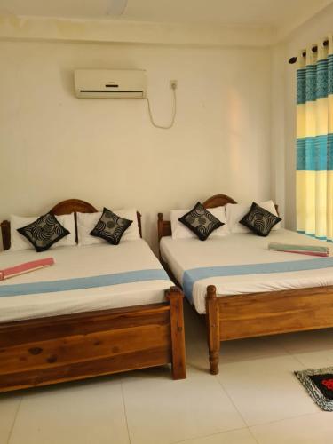 two beds sitting in a room with at Thuruliya Residence in Sigiriya