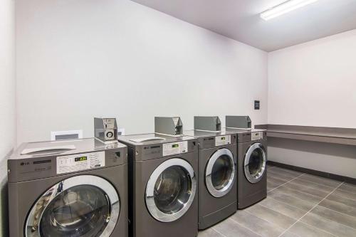 a laundry room with three washing machines in it at Hampton Inn & Suites-Dallas/Richardson in Richardson