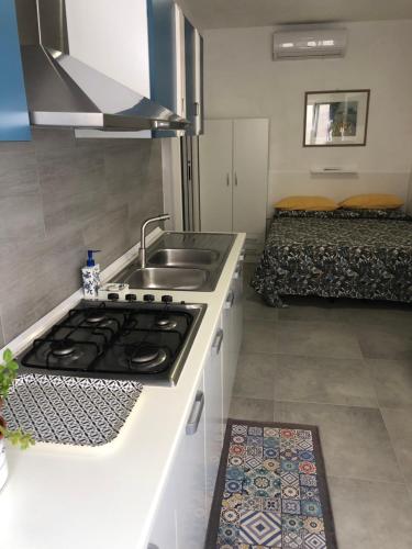 una cucina con lavandino e piano cottura in una stanza di Nido di Puglia 2 a Mola di Bari