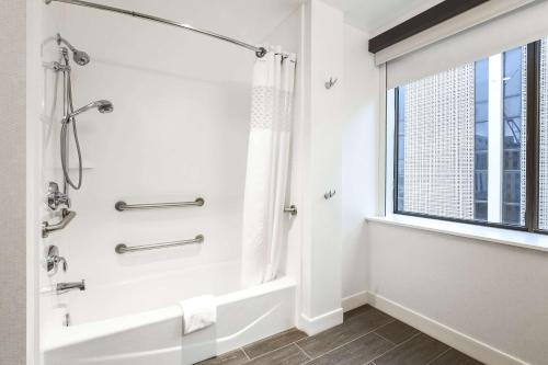 uma casa de banho com um chuveiro e uma janela em Hampton Inn & Suites Dallas Downtown em Dallas
