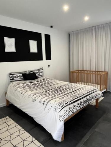 a bedroom with a large bed with a black and white comforter at FURNAS DREAM HOUSE in Furnas
