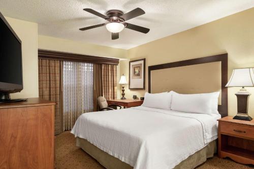 a bedroom with a bed and a flat screen tv at Homewood Suites by Hilton Dallas-Park Central Area in Dallas