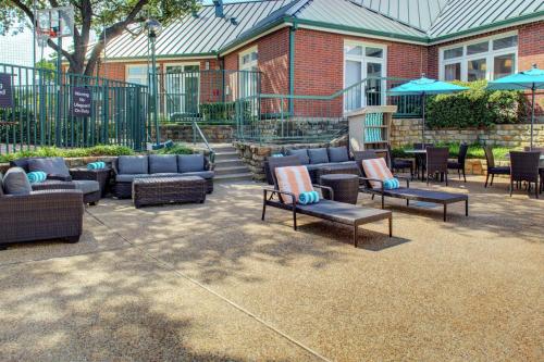 a patio with couches and tables and umbrellas at Homewood Suites by Hilton Dallas-Irving-Las Colinas in Irving