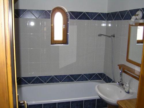 a bathroom with a bath tub and a sink at Csátó Vendégház in Tihany