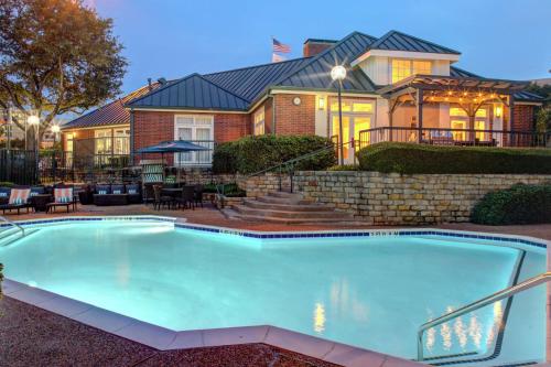 a large swimming pool in front of a house at Homewood Suites by Hilton Dallas-Irving-Las Colinas in Irving