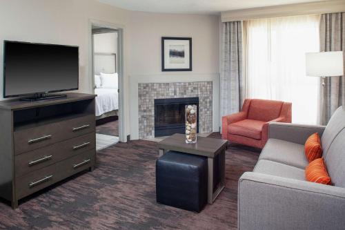 a living room with a couch and a tv and a fireplace at Homewood Suites by Hilton Dallas-Irving-Las Colinas in Irving