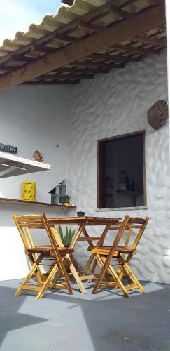 Deux tables de pique-nique en bois avec une télévision sur un mur dans l'établissement Chale Canoa Beach, à Canoa Quebrada