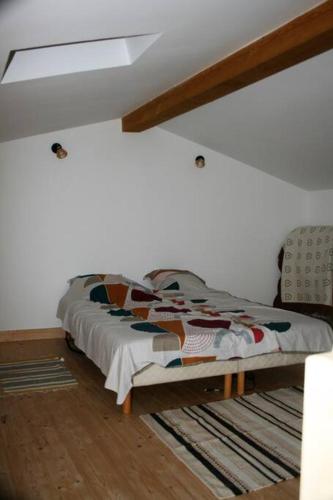 Ce lit se trouve dans un dortoir doté d'un mur blanc. dans l'établissement Gîte cévenol pleine nature tout confort, à Soudorgues