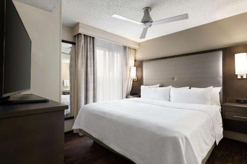 a bedroom with a large white bed and a television at Homewood Suites by Hilton Dallas-Plano in Plano