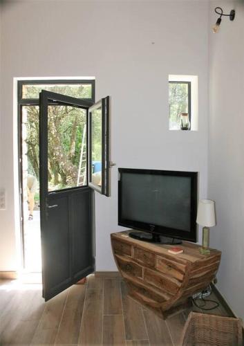 - un salon avec une télévision à écran plat et une porte dans l'établissement Gîte cévenol pleine nature tout confort, à Soudorgues