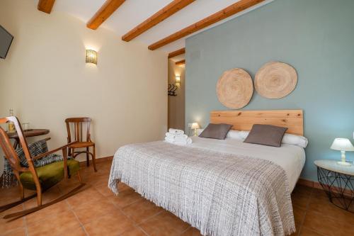 a bedroom with a bed and a table and a chair at Pou De Beca Allotjaments i agroturisme in Vall dʼAlba