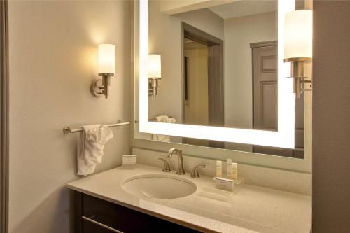 a bathroom with a sink and a large mirror at Homewood Suites by Hilton Dayton South in Miamisburg