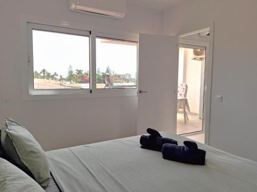 ein weißes Schlafzimmer mit einem Bett und einem Fenster in der Unterkunft Joya de Iguazu - Centrum Playa del Inglés in Maspalomas