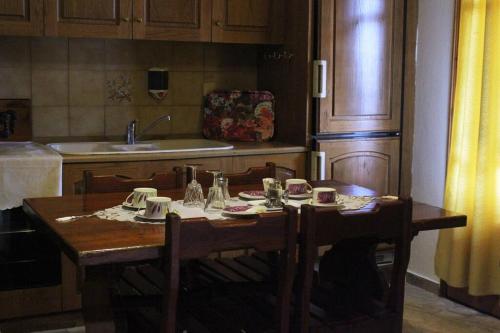 eine Küche mit einem Holztisch mit Stühlen und einem Waschbecken in der Unterkunft Villa Apartment with 3 bedrooms in Polykastro