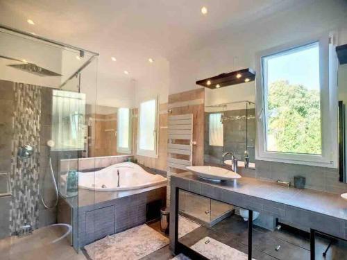 La grande salle de bains est pourvue de 2 lavabos et d'une baignoire. dans l'établissement Superb Villa, swimming pool, secluded gardens, à Cannes