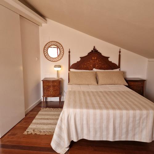ein Schlafzimmer mit einem großen Bett und einem Spiegel in der Unterkunft CASAS de CONSTÂNCIA in Constância