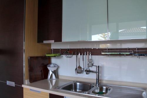 eine Küche mit einem Waschbecken und Küchenutensilien an der Wand in der Unterkunft Varandas do Mar Apartamento T2R frente mar Olhos de gua Albufeira in Olhos de Água