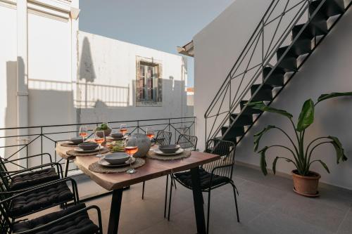 uma mesa e cadeiras numa varanda com uma escada em Soleil boutique house with terrace em Retimno