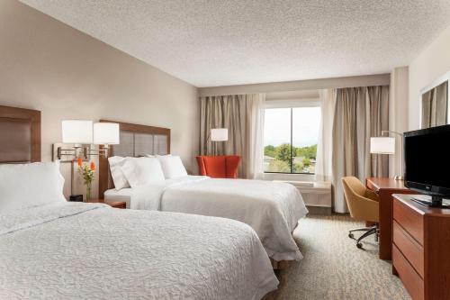 una camera d'albergo con due letti e una televisione di Hampton Inn & Suites Denver-Cherry Creek a Denver