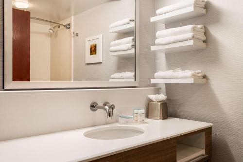 a bathroom with a sink and a mirror and towels at Hampton Inn & Suites Denver-Cherry Creek in Denver