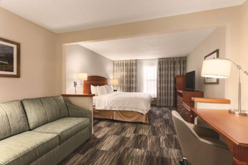 a hotel room with a bed and a couch at Hampton Inn Denver - Northwest Westminster in Westminster