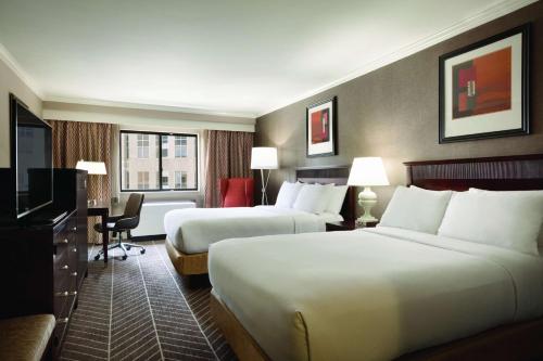 a hotel room with two beds and a television at Hilton Arlington in Arlington