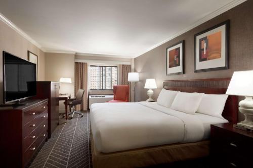 a hotel room with a large bed and a desk at Hilton Arlington in Arlington