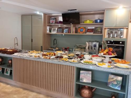 a buffet with many plates of food on a counter at Hotel Chateau in Campos do Jordão