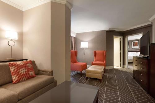 a living room with a couch and two chairs at Hilton Arlington in Arlington