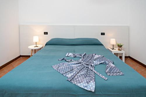 - un lit avec une couette bleue et une robe dans l'établissement VILLA IDA - Regarda Travel, à Costermano