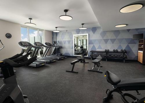a gym with treadmills and chairs in a room at Canopy By Hilton Dallas Frisco Station in Frisco